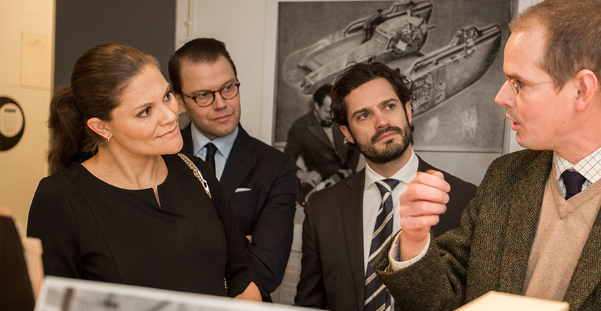 Kronprinsessan Victoria, prins Carl Philip och prins Daniel pratar med Krister Hillerud, vice VD, om Ericssons företagsarkiv på Centrum för Näringslivshistoria, (Foto: Michael Folmer, abcpress.se.)